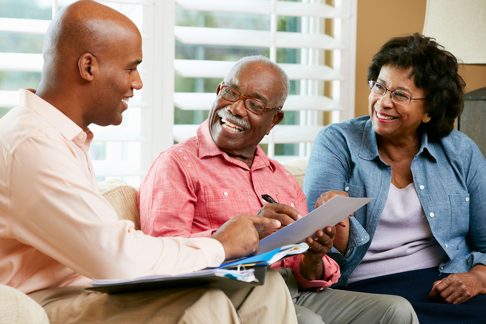 Estate planning attorney Talking To Senior Couple At Home Estate planning lawyer assisting couple with their documents